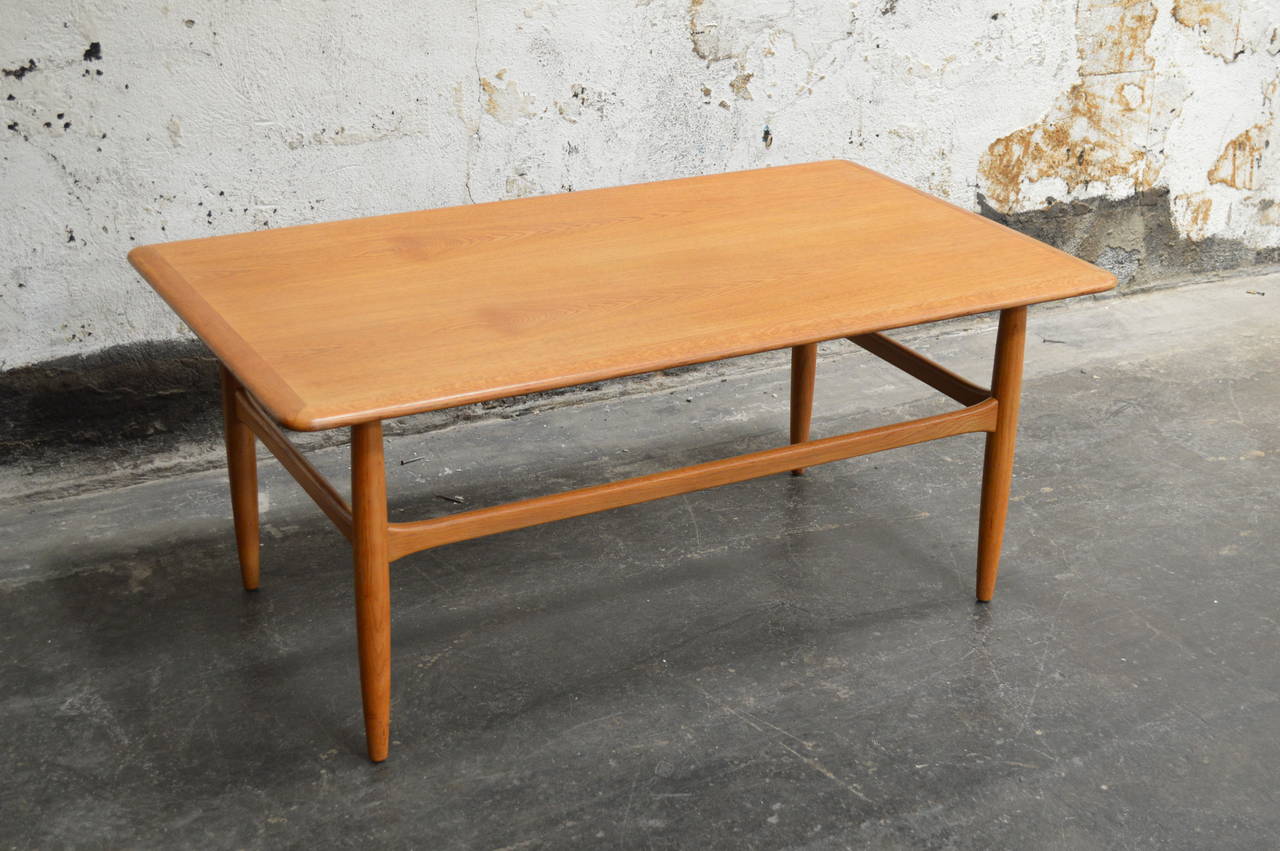 Handsome Mid-Century Modern coffee table with round tapered legs and stretchers. Nicely detailed top and perfectly scaled for a coffee table.