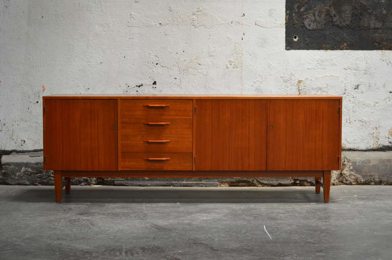 Swedish Mid-Century Modern teak credenza, buffet or sideboard. Four dovetailed top drawers. All drawers are felt lined for silverware. Locking cabinet doors interior with shelves. Key Included.
