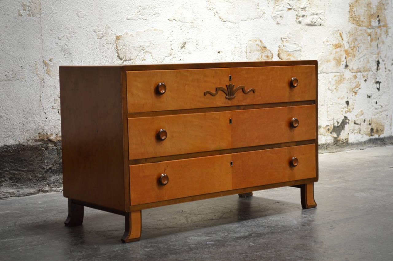 Swedish Art Deco chest fitted with three spacious dovetailed drawers in beautiful golden flame birch sides and legs. This chest wooden pulls and unique flared legs. Perfectly scaled for just about anywhere in the home.