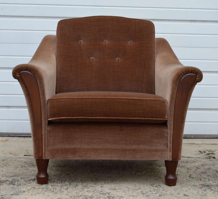Pair of 1970's club chairs with dramatic flared arms with wood trim in original brown mohair wool velvet. The back cushions are button tufted which accentuates the original luminescent mohair velvet. The chairs can appear lighter or darker depending