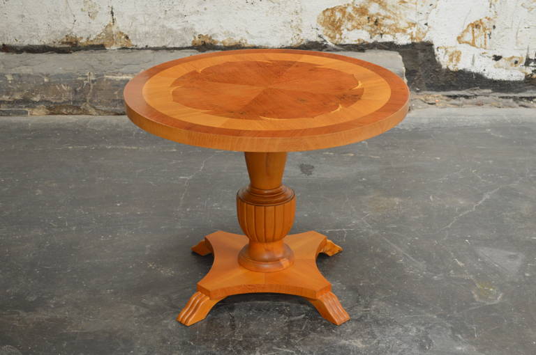 Swedish Deco pedestal end or side table in golden elm. The table top is paneled and inlaid with intarsia of contrasting birch wood. It is the perfect size beside a club chair, at the end of a sofa, or as a very stylish bedside table.
