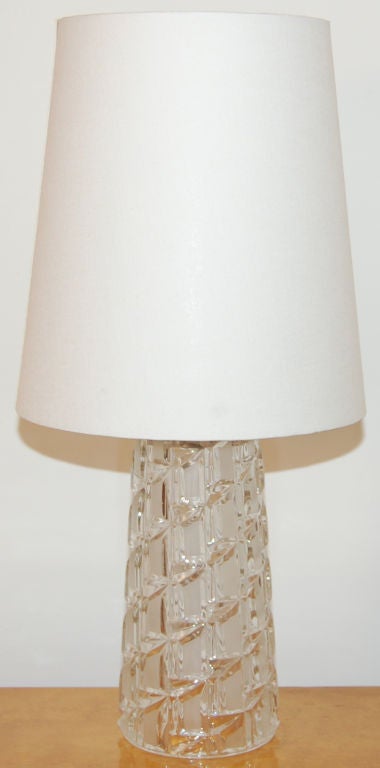 Swedish Modern cylindrical table lamp. Lamp base is clear and made of frosted cut glass. Vintage MCM lamp base comes with a new natural fabric shade, also made in Sweden. This Midcentury Modern lamp complements a variety of design styles including
