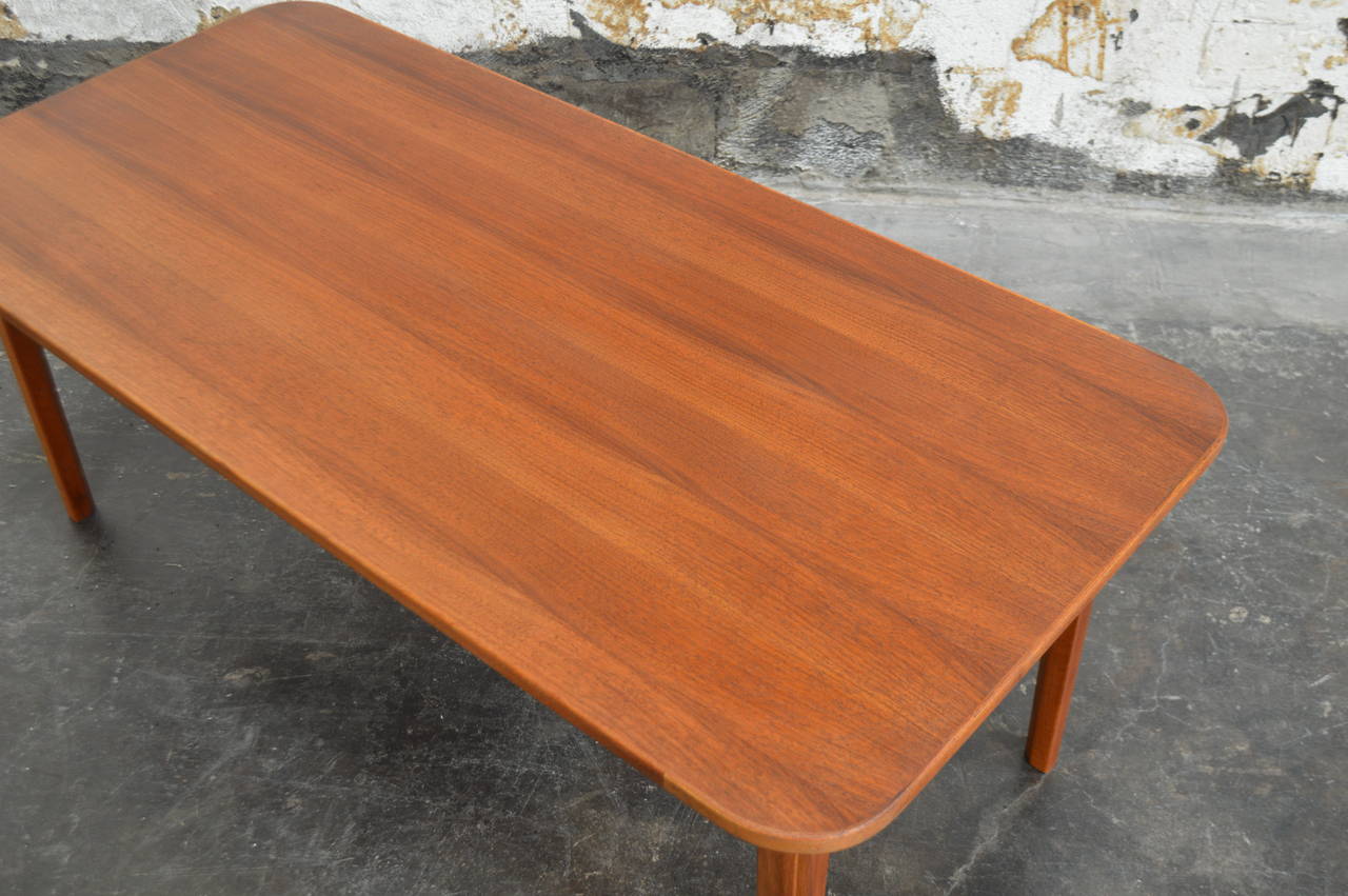Mid-Century Modern teak coffee table by renowned Swedish furniture designer Carl Malmsten (1888-1972). Detailed corners and rounded butterfly legs. A wonderful midmod addition to your living space and complementary to a variety of interior styles,
