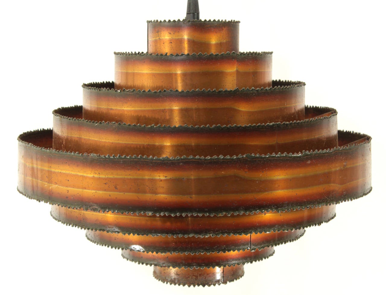 A stunning Mid-Century Brutalist pendant made from bands of copper, artfully patinated and textured with acid, and torch cut to a serrated edge. In excellent vintage condition. Newly re-wired to U.S. standards and includes new black canopy and all