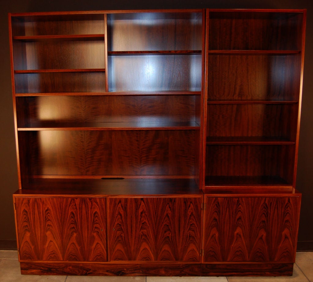 Gorgeous jacaranda bookcases and credenzas sold as a set - by Poul Hundevad of Hundevad Furniture of Denmark. Book-matched jacaranda veneer is extraordinary.  Adjustable shelves on lower part and within cabinets.  A wonderful addition to a library,