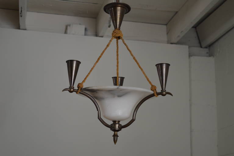 Handsome Swedish chandelier of alabaster shot with black and grey veining from the turn of last century. Electrified on the interior with room for one 75-100 watt bulb and three iron candelabra arms that hold three real wax candles. Original iron