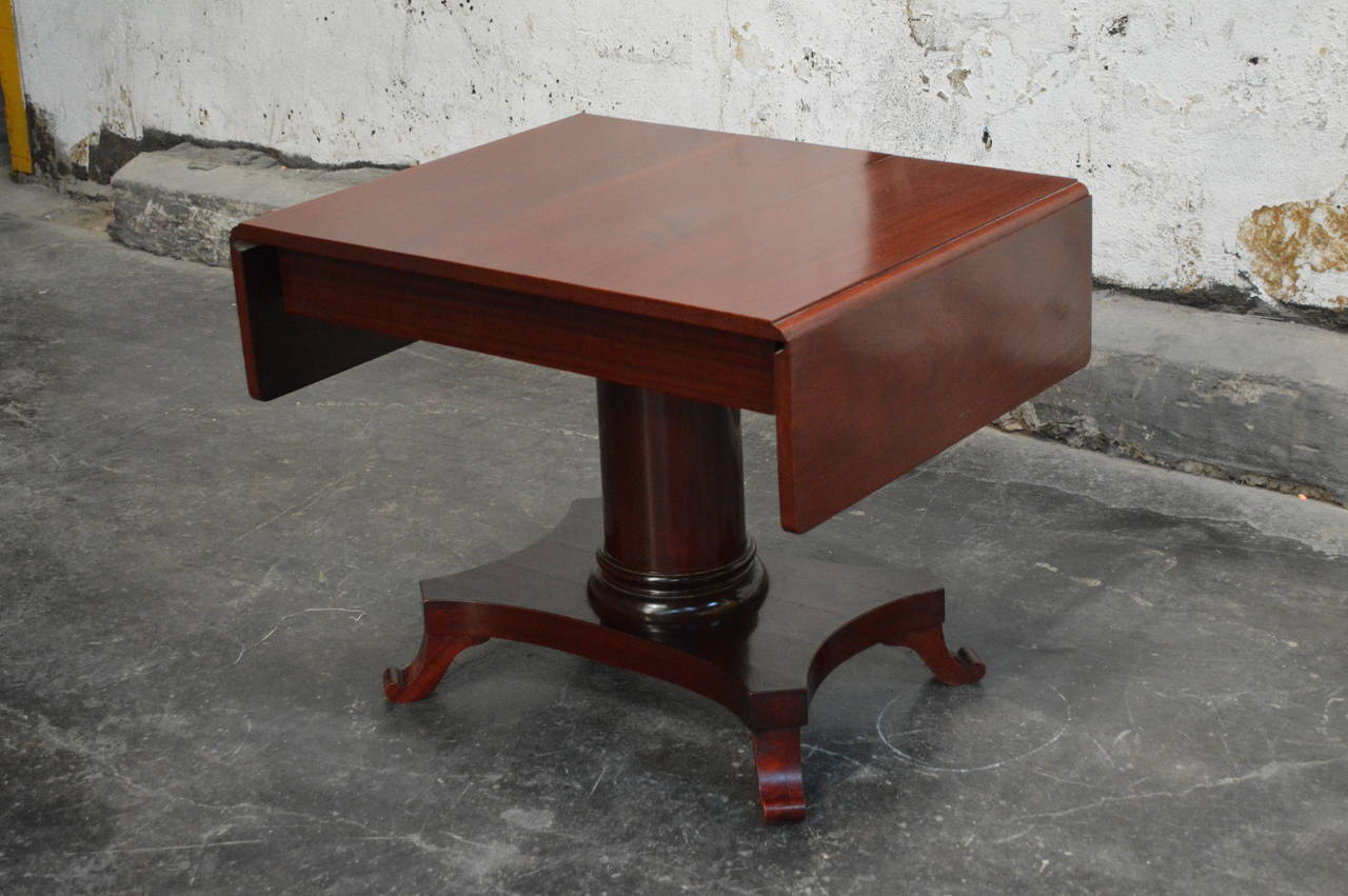 Karl Johan drop-leaf center table of red mahogany gracefully shaped pedestal base.

Dimensions:
52.5