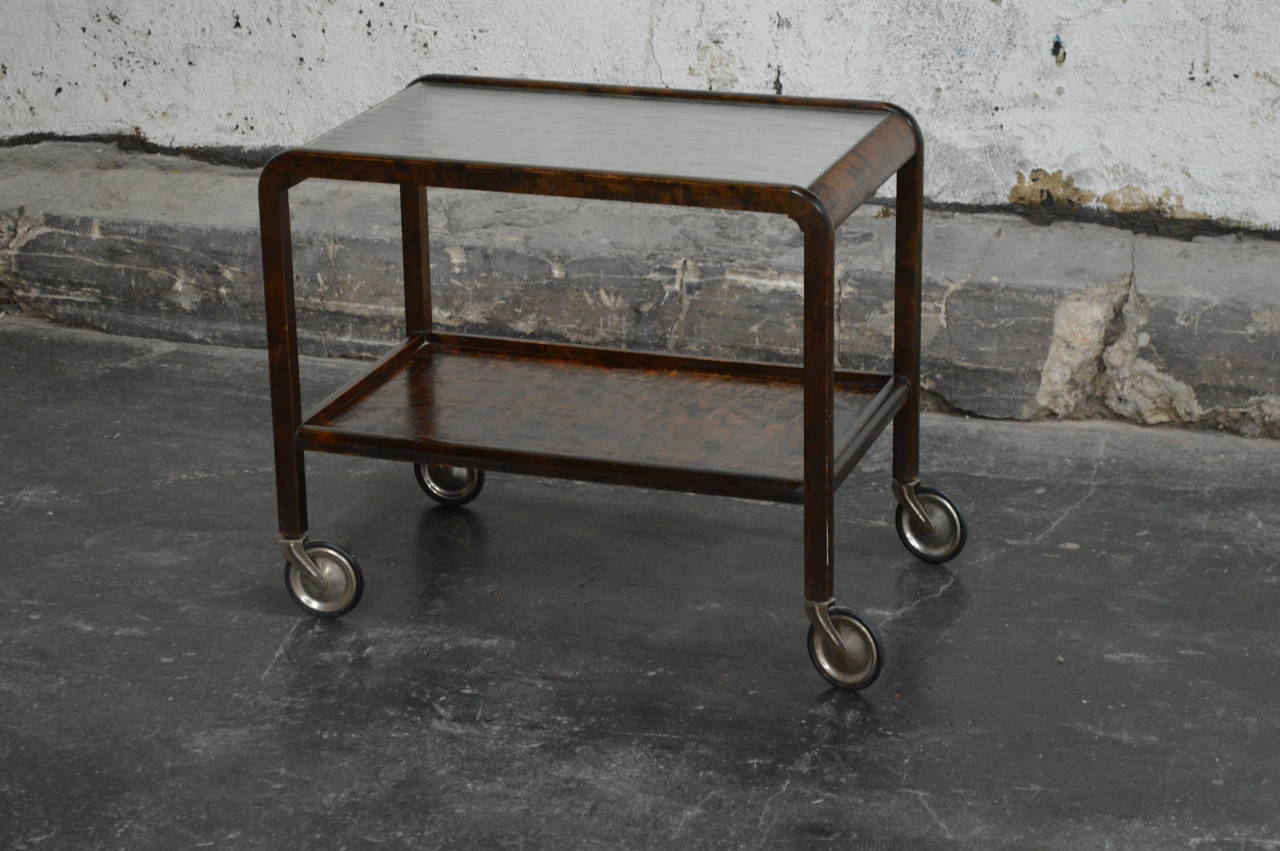 Art Deco bar cart made of Swedish flame birch. Two-tiered serving cart with wheels and a glass top. Curved shape that complements a variety of styles including Deco, Art Nouveau, MCM, Minimalist, Classic and more.