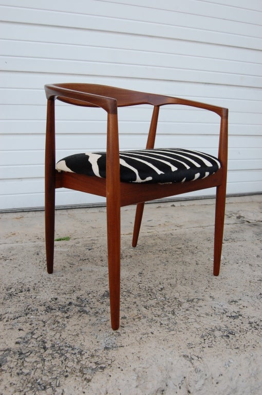 Sculptural armchair of natural teak. Seat is newly padded and reupholstered in striking zebra print 