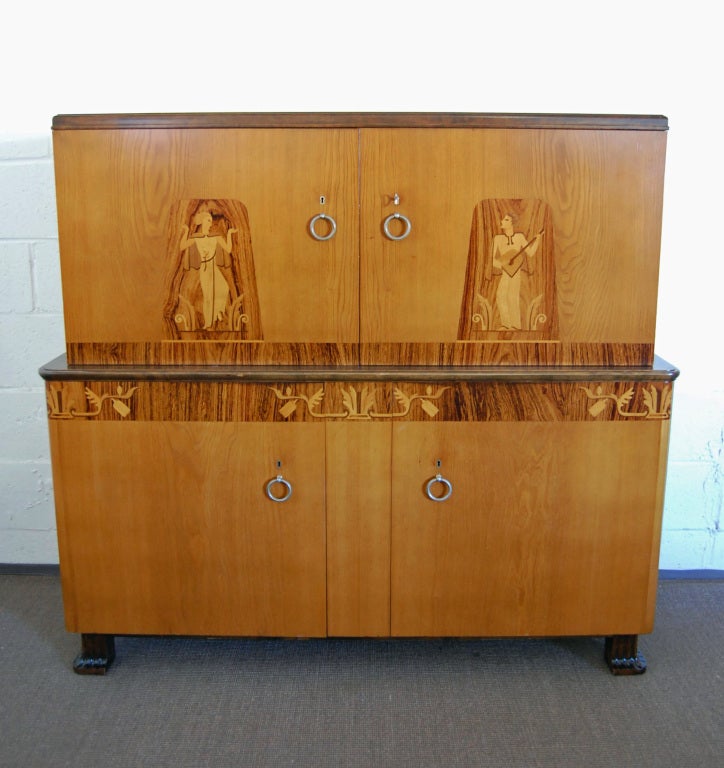 This Swedish Art Deco - verging on Art Moderne - storage/dining/bar cabinet belies that form follows function. In this case, they are considered equals! Crafted in golden elm, dark flame birch, rosewood and a host of exotic hardwood inlays, this