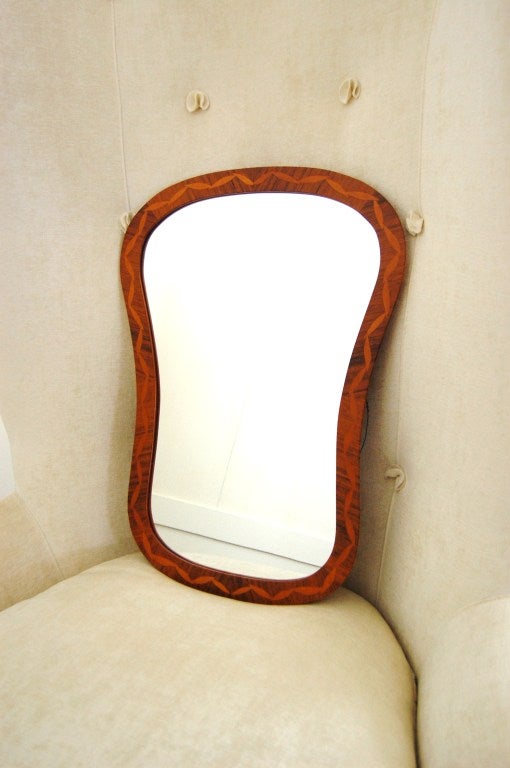 Lovely shaped intarsia (inlaid) mirror of rosewood with golden birch inlay.  Of the 1920's 
