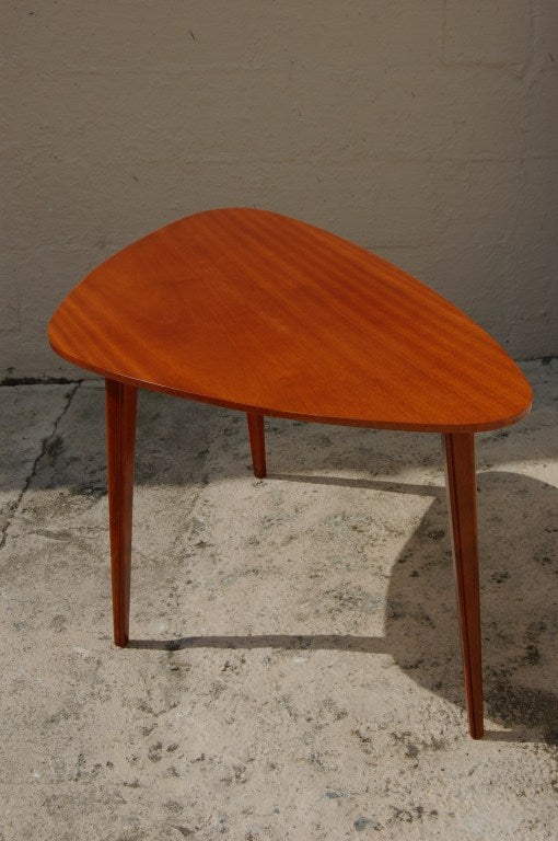 Unusual triangular coffee table. Bookmatched mahogany top on three stylized flame birch legs.

Two sides measure 27.5