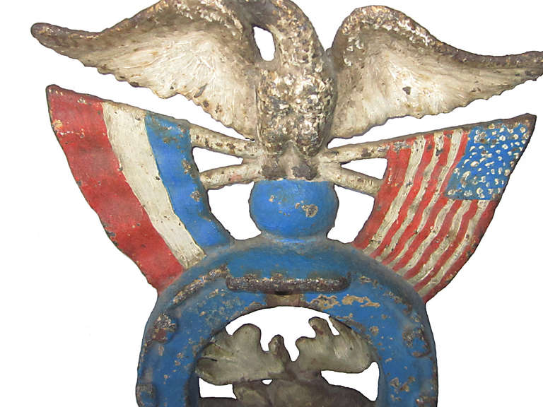 Early 1900's unusual cast iron Good Luck lodge memento in a red, white and blue patriotic motif and showing an eagle over crossed flags over a horseshoe with a moose head, all in as found surface and condition.