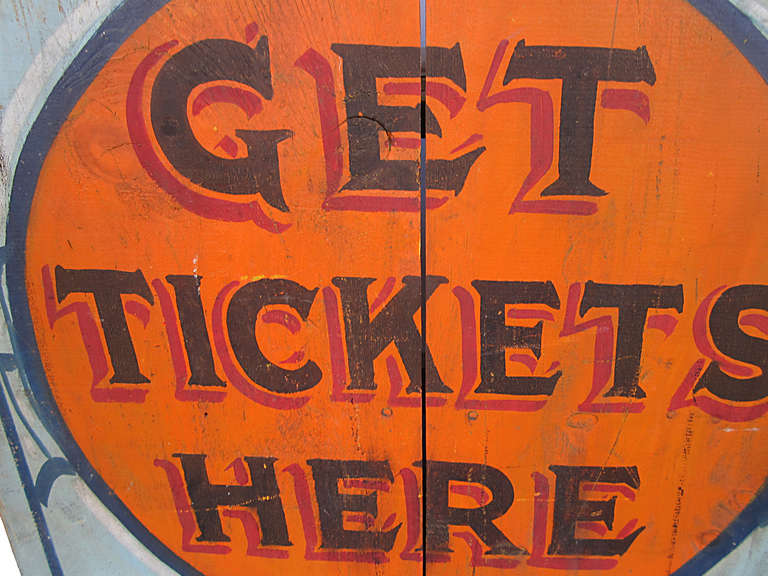 Early 1900 hand made three sided whimsical wood ticket booth on a raised foot and showing a center medallion 'Get Tickets Here' in fancy black lettering with red drop shadowing on a brilliant orange circle with dark and light blue and white