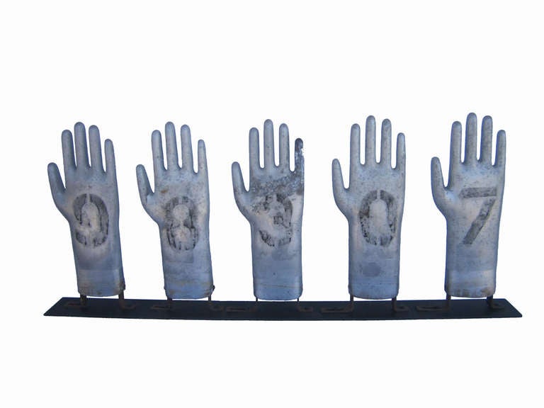 Circa 1930 set of five aluminum glove molds with original numbers and surface, original cast iron 'L' brackets at base of each, contemporary table mount