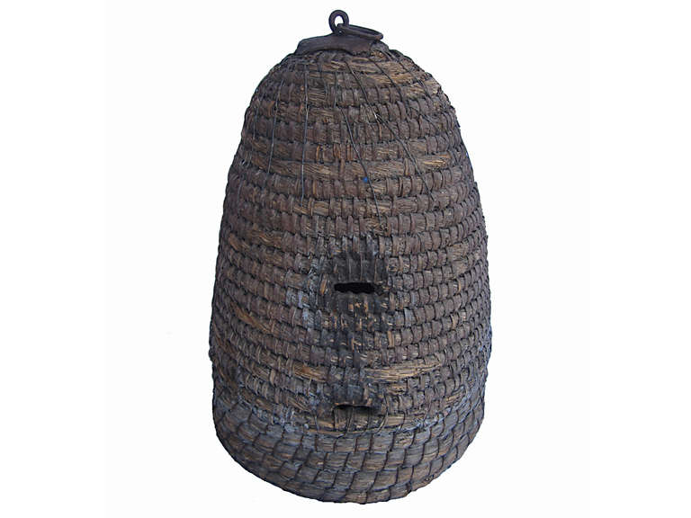 Late 19th century hand-formed rye straw bee skep with an unusual cast iron plate and ring at top, Pennsylvania origin.