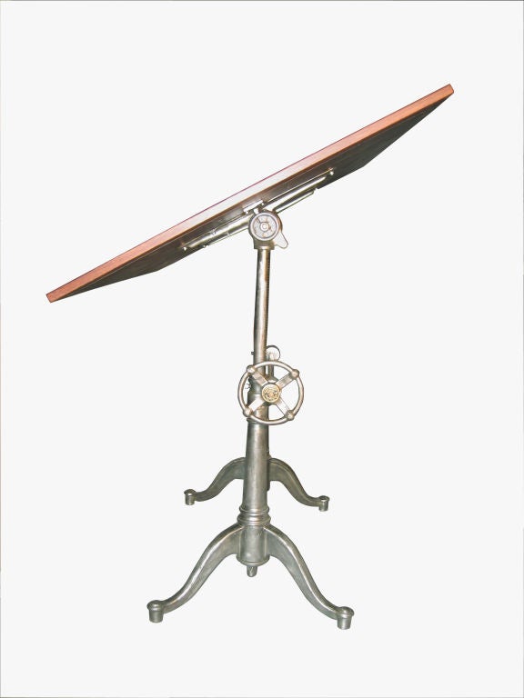 An American drafting table from Worchester,Mass..Early 20th Century. The mahogany rectangular top supported by a mecanical<br />
base of polished cast iron and steel.