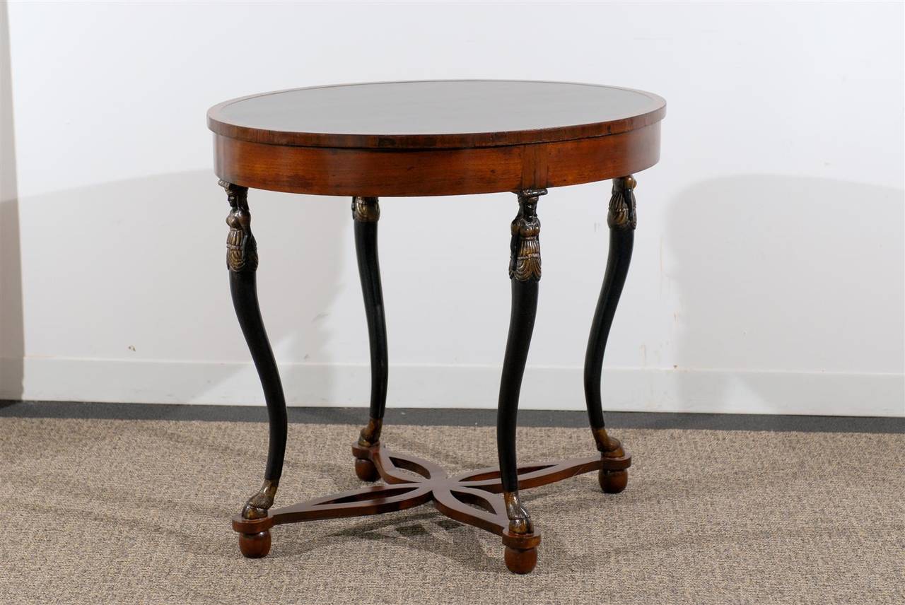 Oval neoclassical style table raised by Carved Figures.