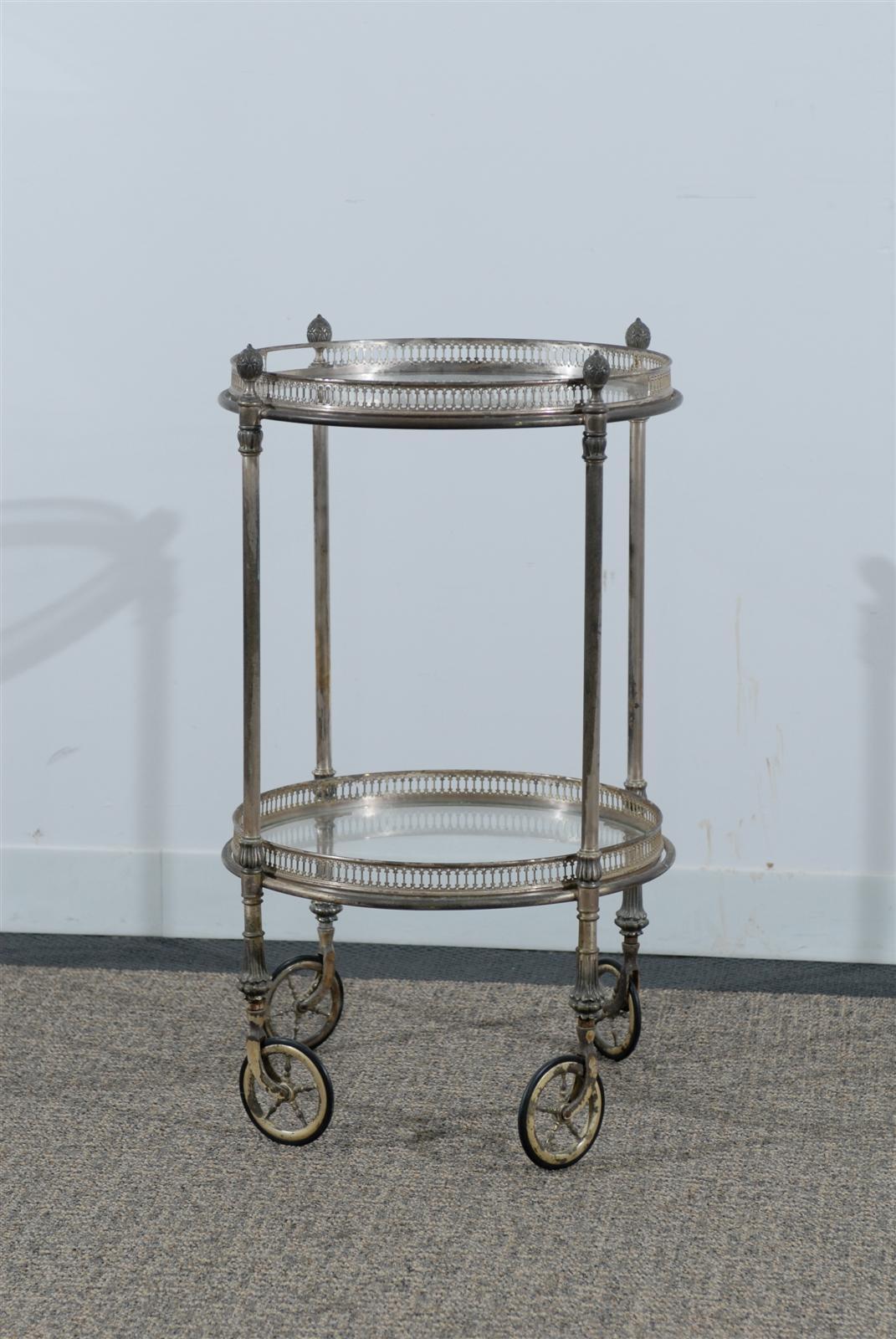 Very chic round silver patina tea cart with removable top tray with glass shelves top and bottom on wheels.