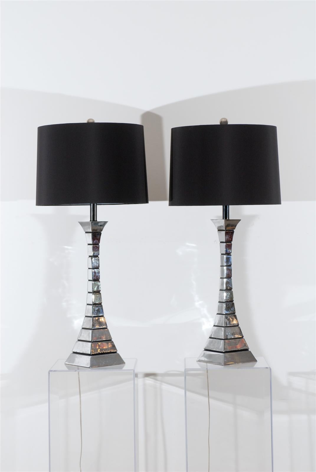 Striking pair of midcentury chrome-plated lamps. Shown with black silk drum shades. (Shades available at additional charge.) Rewired with clear cords and chrome ball finials. 

Measures: 35