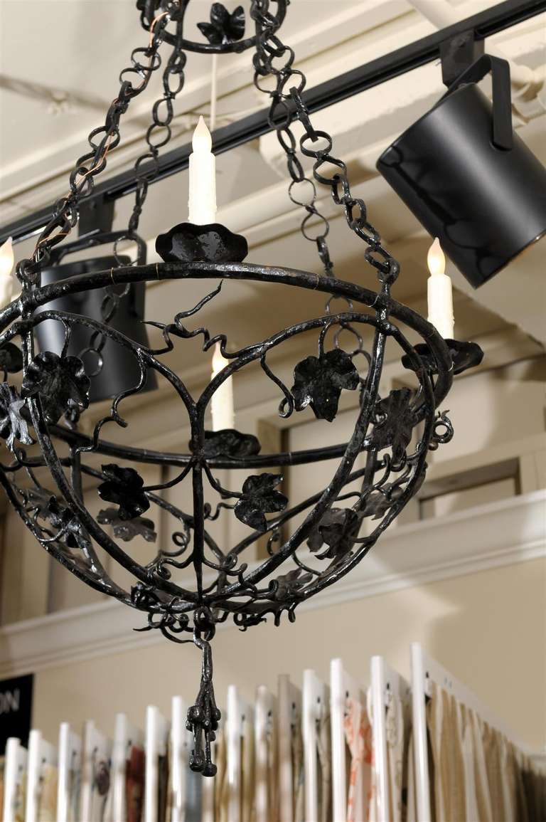 Unusual antique four light iron chandelier in ebony patina. Origin France.
Very attractive ivy and scroll design.