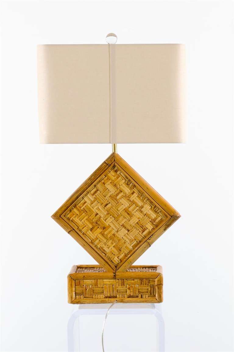 A stunning pair of vintage rattan lamps, circa 1970. Rich and warm pieces that will add wonderful scale and texture to any room. Excellent Restored Condition. Rewired using clear cord and complete with new neutral linen shades ( size: 18