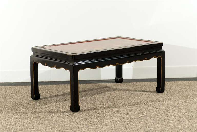 Black lacquered Chinese style coffee table with red chinnoiserie
decorated inserted panel.