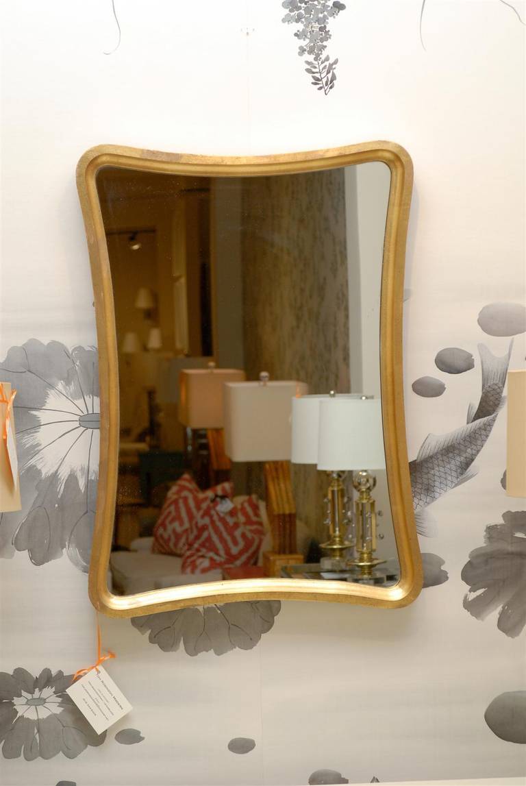 A simple and elegant pair of Modern mirrors, circa 1970. Fabulous hardwood Silhouette finished in gold leaf. Wonderful patina. Exquisite jewelry! Excellent vintage condition. The price listed is for the pair.
