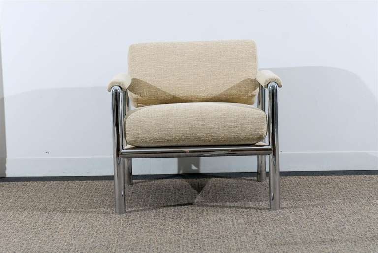 A striking pair of tubular chrome lounge/club chairs. Semi-attached seat with a loose cushion back, the chairs are heavy and substantial. The chrome is in Excellent Vintage Condition, new upholstery in a neutral raw silk fabric. A very unusual