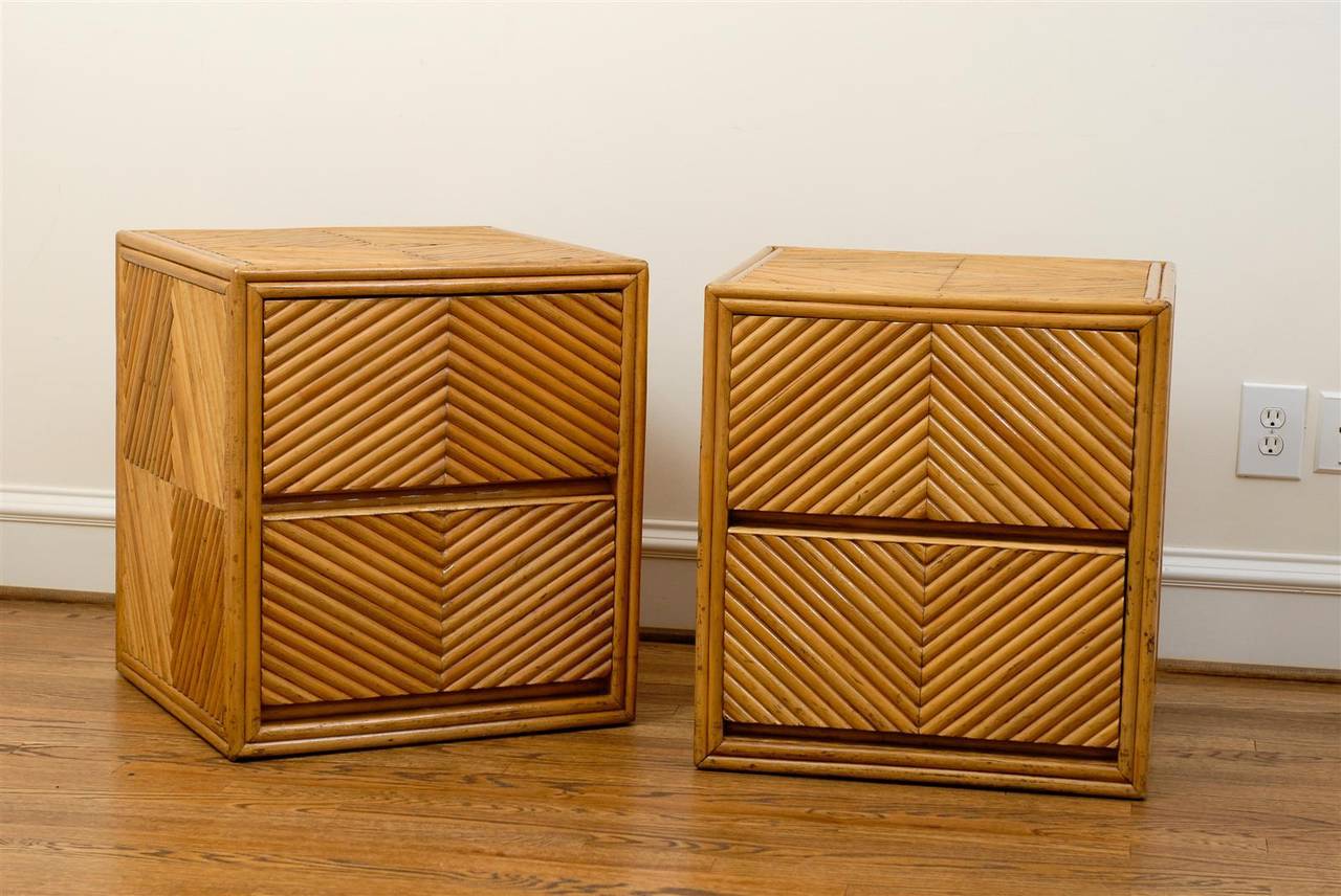 A beautiful pair of two-drawer bamboo cube chests, circa 1970. Split bamboo veneer painstakingly applied over solid mahogany case construction. Fabulous chevron detail highlight the cubes. May serve as end tables or night stands. These functional,