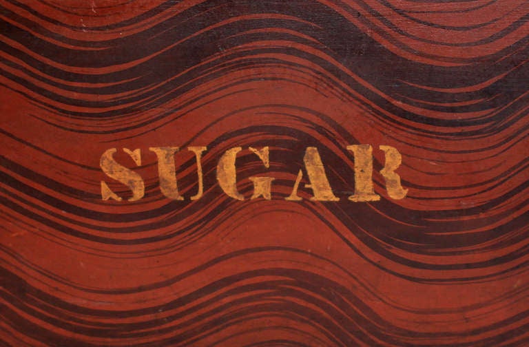 Excellent, large, original grain painted box, battened lift-top lid with turned knob. Dramatic grain painting in deep rust red and black on all four sides and top, with the word “SUGAR” stenciled in gold on the front. All original. Most likely made