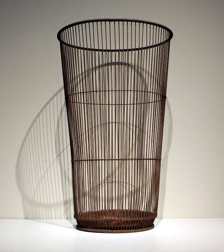 Tall wire basket with nice even rusted patina. The wire wraps nicely around the bottom and gives a little lift. A great umbrella stand or container for inside the house or in the garden. American, early 20th century.