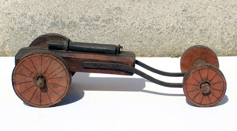 Interesting form - a wrought iron and painted wood signal canon on wheels, nice lines and constructed form; American, circa 1850.