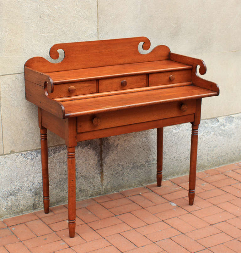 Fine writing desk with notable detail, including cut scrolls on the backsplash and both sides, inlaid knobs on the lower drawer, five dovetailed drawers on two tiers, nicely turned legs; as well as good proportions. Because of the lower drawer, it