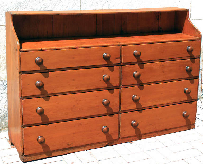 An appealing and unusual form, this double chest features 8 drawers, a shelf top, shallow body and turned knobs. The body is long leaf pine, it is possibly from the southern states and dates circa 1850. The finish is a mellow, honey tone. Drawers