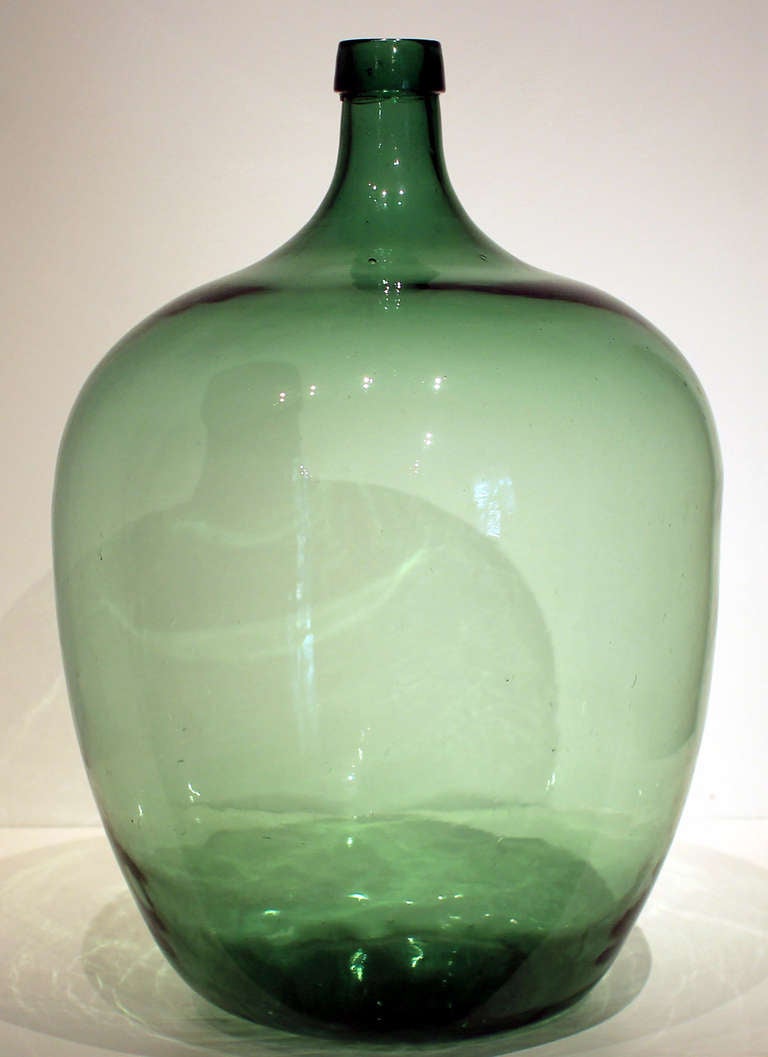 Extremely large and fine, deep green blown glass demijohn bottle; American, circa 1875. Excellent condition.