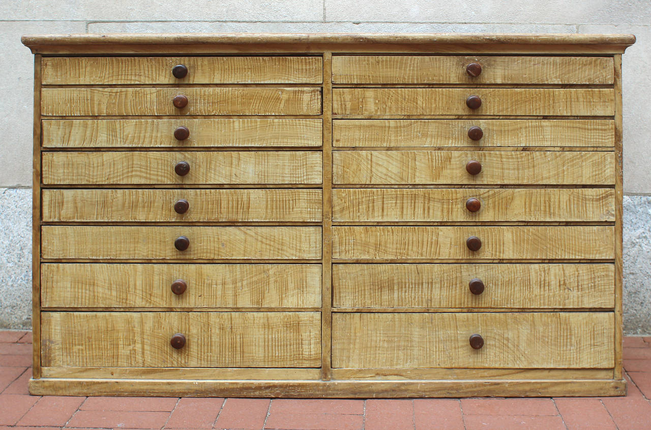 Small-scale grain painted storage counter with 16 graduated, dovetailed drawers and original turned knobs; pine in original paint decoration, American, circa 1860. Excellent original condition. Would work well in a hall or entryway or as a server /