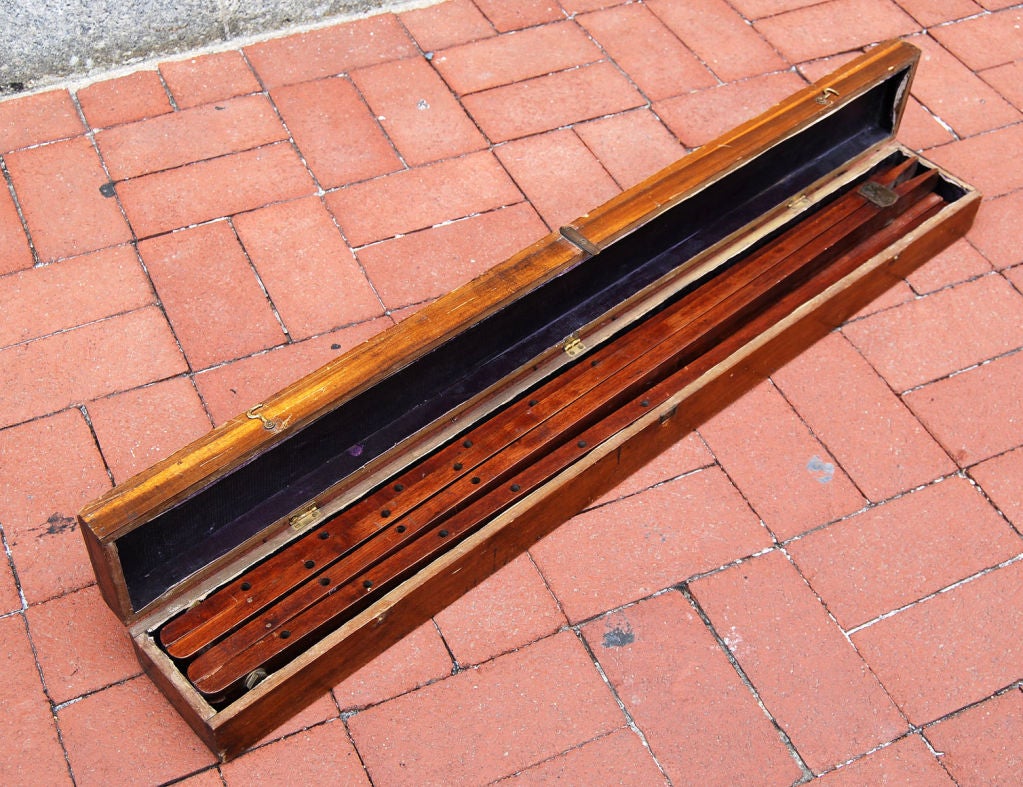 Well-constructed mahogany folding easel with four pegs and in original carrying box with brass hardware. The easel itself has excellent original brass hardware; each leg is secured by small brass hinged pegs that fold into notches in the wood. A