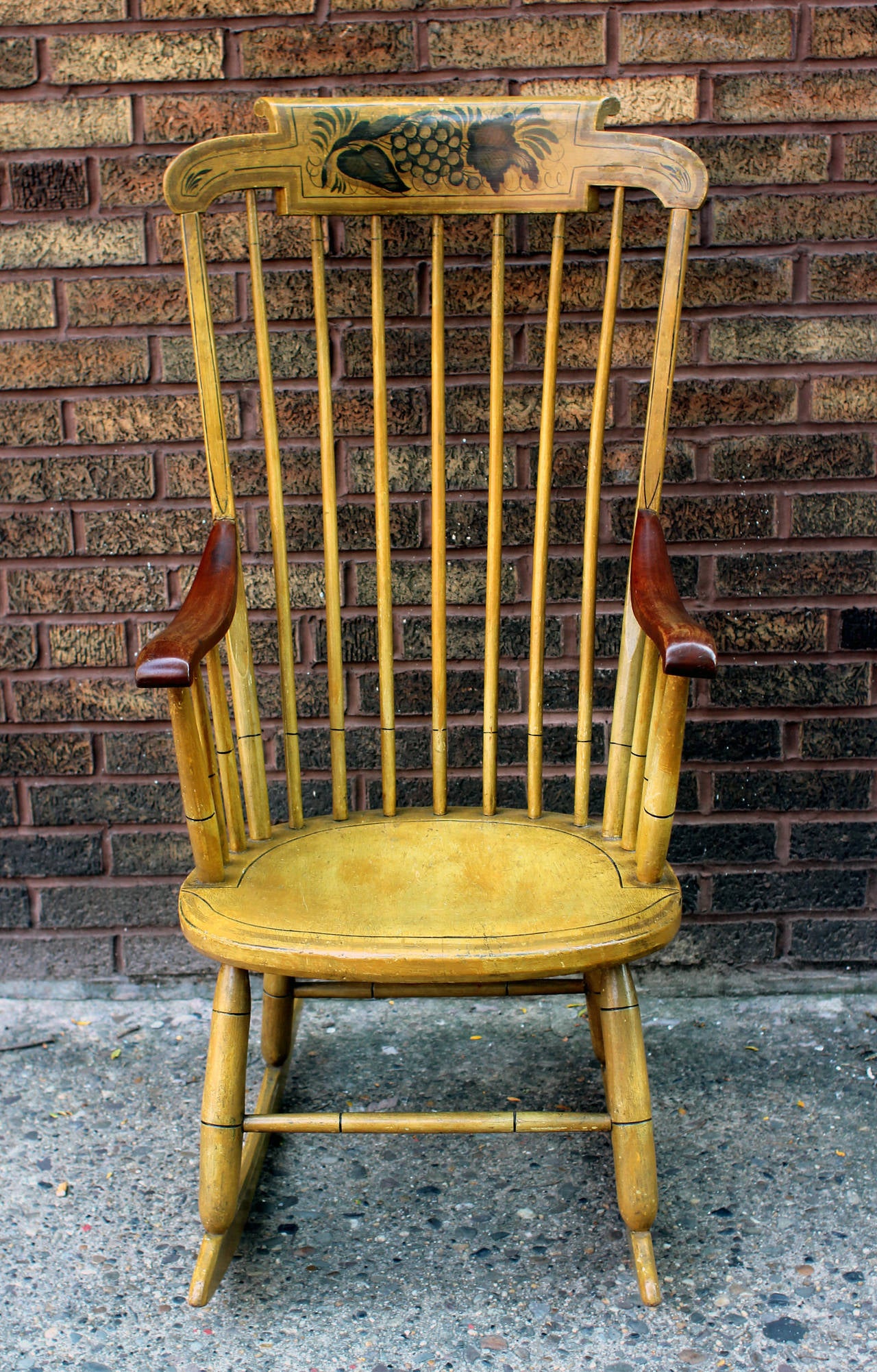 Handsome New England rocker in fine, original yellow paint and decoration and nicely worn mahogany arms. The paint decoration focuses on a handsome bunch of fat grapes, a more unusual subject than flowers, which were used more often. Nicely sturdy