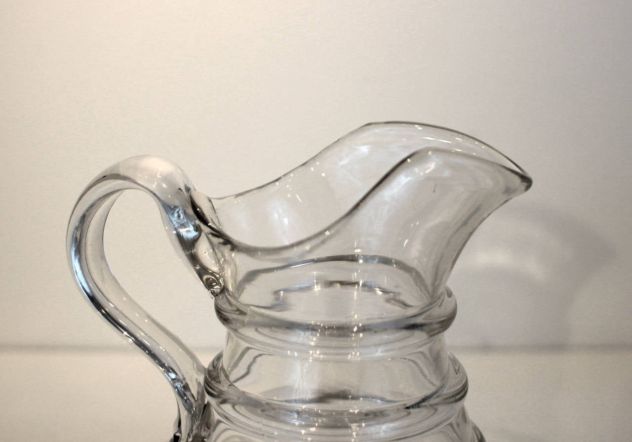 Fine and heavy handblown glass pitcher with applied handle and four-ring decoration. Probably Pittsburgh, circa 1850.