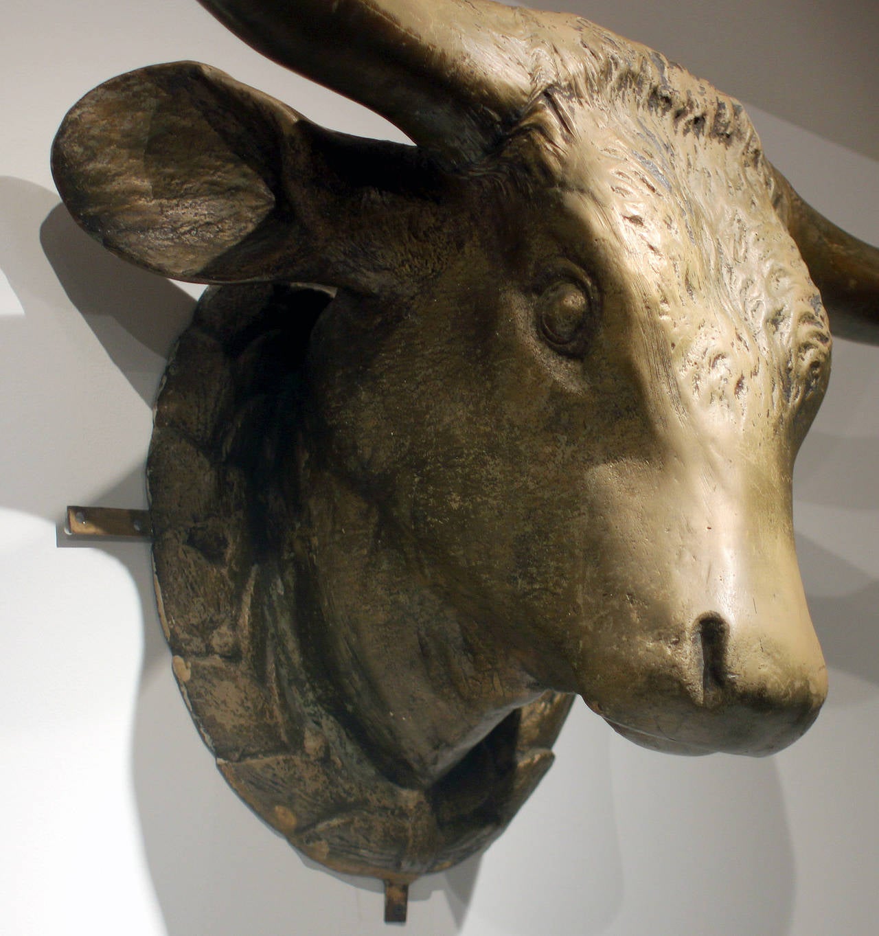 This is a huge steer head - a shop sign for a butcher, gold painted fiberglass and wood, with four brackets, American, 20th century.