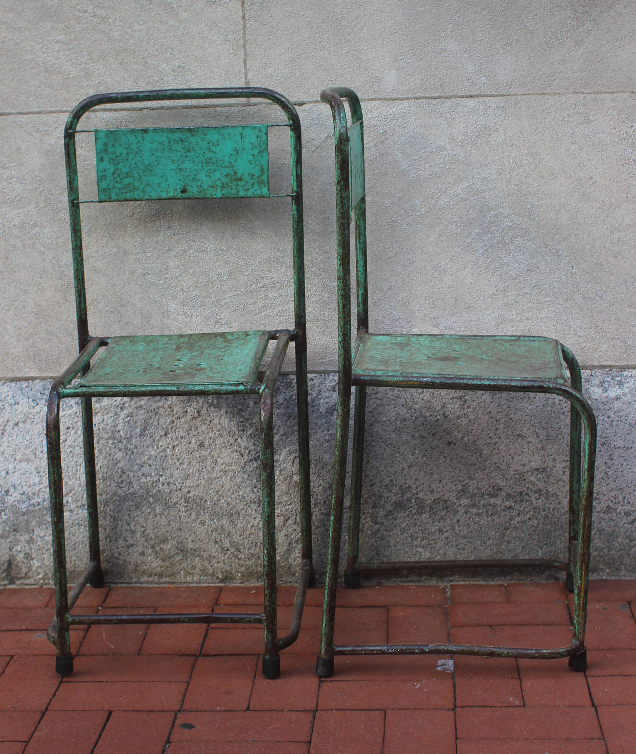 Pair of painted metal chairs in an interesting teal green paint, circa 1940. Sturdy and comfortable.