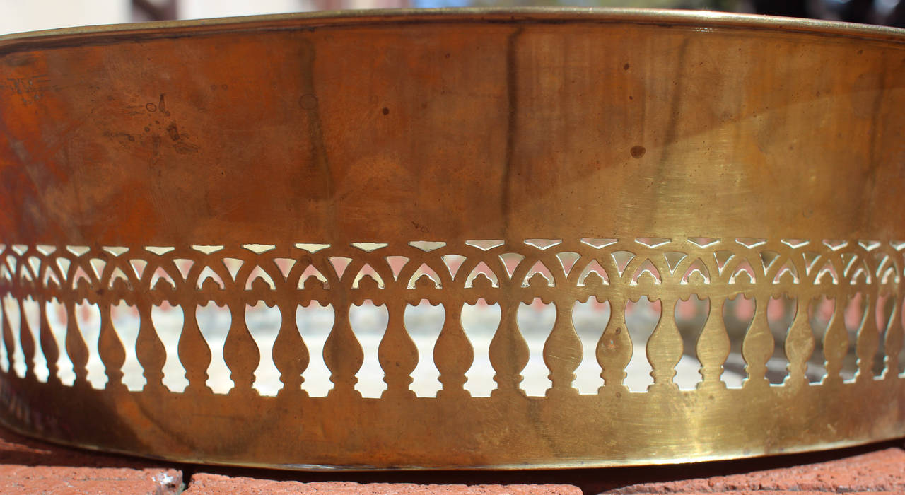 Handsome brass basket with a cut pattern around the sides, likely made by someone who made fenders, as well. English, early 19th century. Would make a great centerpiece.