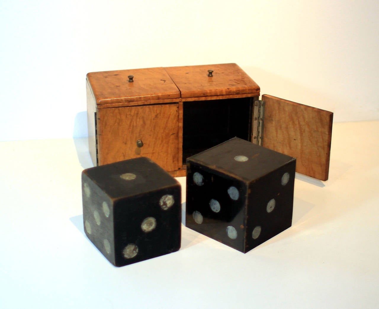 Fine figured maple magician's magic trick box with dice, one wood and one four-sided metal, all original; late 19th century, American. Very handsome.
