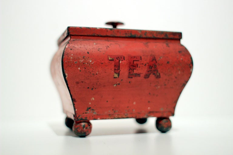 Small and terrific red painted tin tea bin with Chinoiserie lines, ball feet, hinged lid, all original. English, circa 1860.