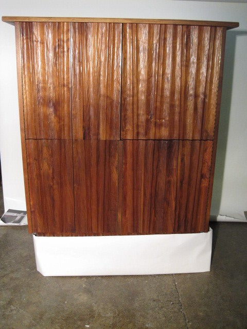 A massive free standing floor cabinet by American Studio Movement artist and former George Nakashima craftsman Gino Russo. This is a custom made cabinet having two sets of doors cocealing a media center or combination bar. There is a sliding