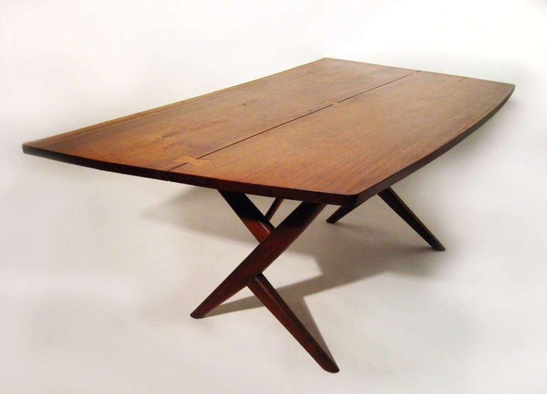 A rare form having a Walnut free edge top. Top gently bows in on oneside and out on the other side. Several butterflies joins the two slabs together. Walnut canted legs supporting the top. This form can be used as a dinning table table or as a desk.