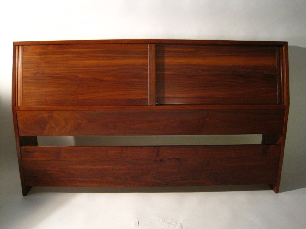 A solid Walnut headboard also serves as a storage cabinet. Very simple and clean in design. Well thought out. Beautiful selection of Walnut boards through out.