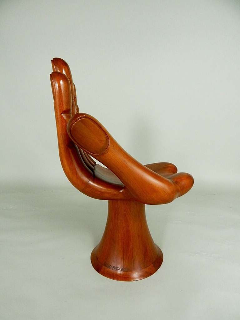 Sculpted left hand chair made of Mahogany having the typical elongated and slender fingers meeting a deep formed palm.