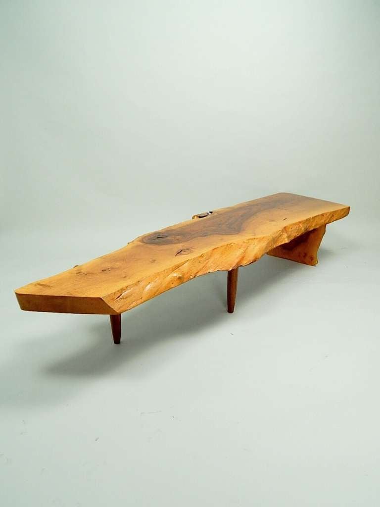 A thick English wallnut slab top having intense center grain pattern.
Natural edge formations on one side and smoothed edge on opposite side  makes this table a very interesting form. Upright and two Walnut legs supporting top.